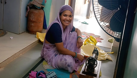 Indian girl taking a sewing machine and stitches her hair