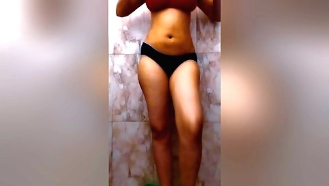 Sexy redhead in a red bikini naked in front of a mirror